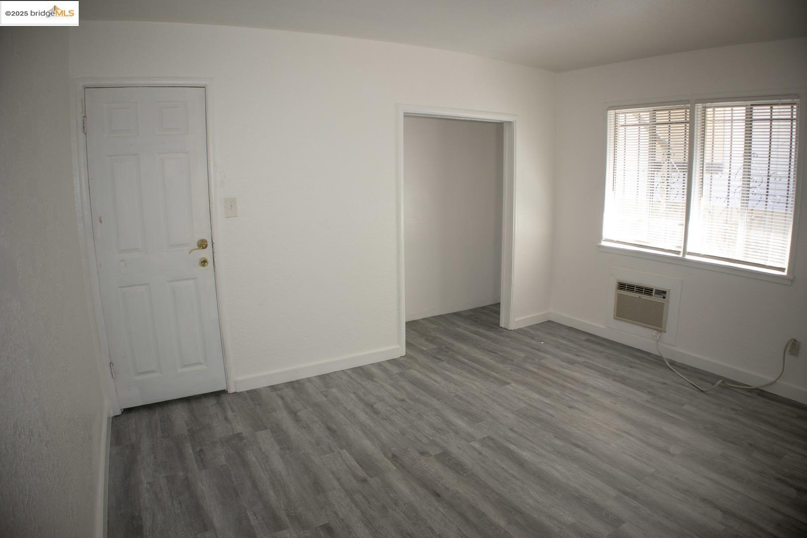 6921 Flora Street Oakland, CA 94621 - Photo 16 of 22 an empty room with wooden floor and windows