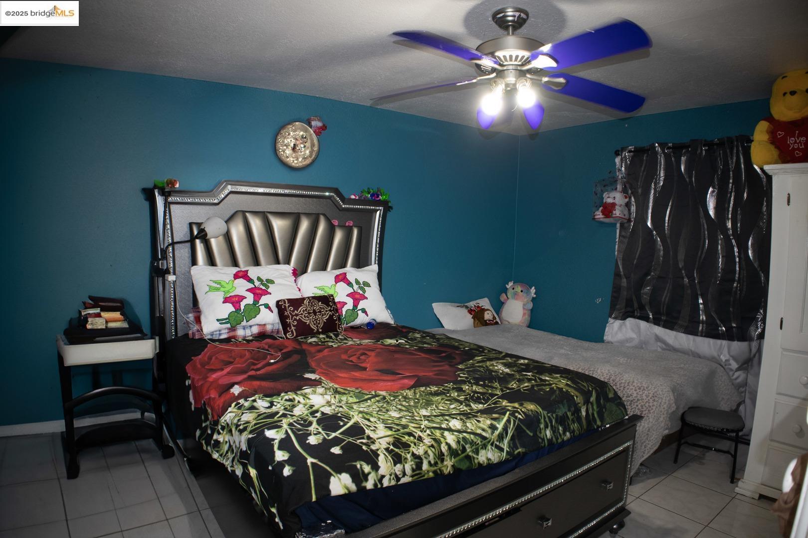 6921 Flora Street Oakland, CA 94621 - Photo 20 of 22 a bedroom with a bed and a chandelier