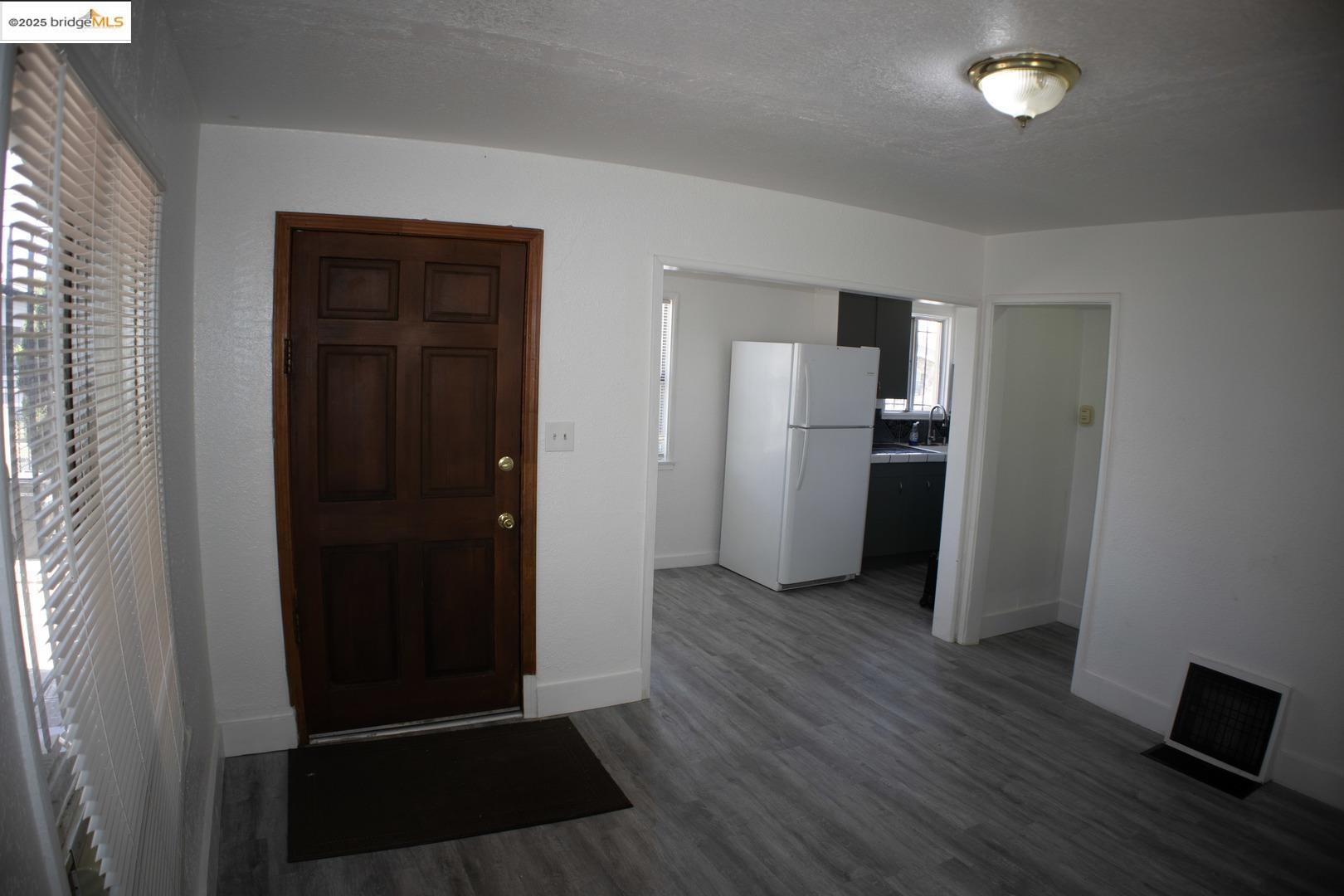 6921 Flora Street Oakland, CA 94621 - Photo 7 of 22 a view of a kitchen with refrigerator and wooden floor