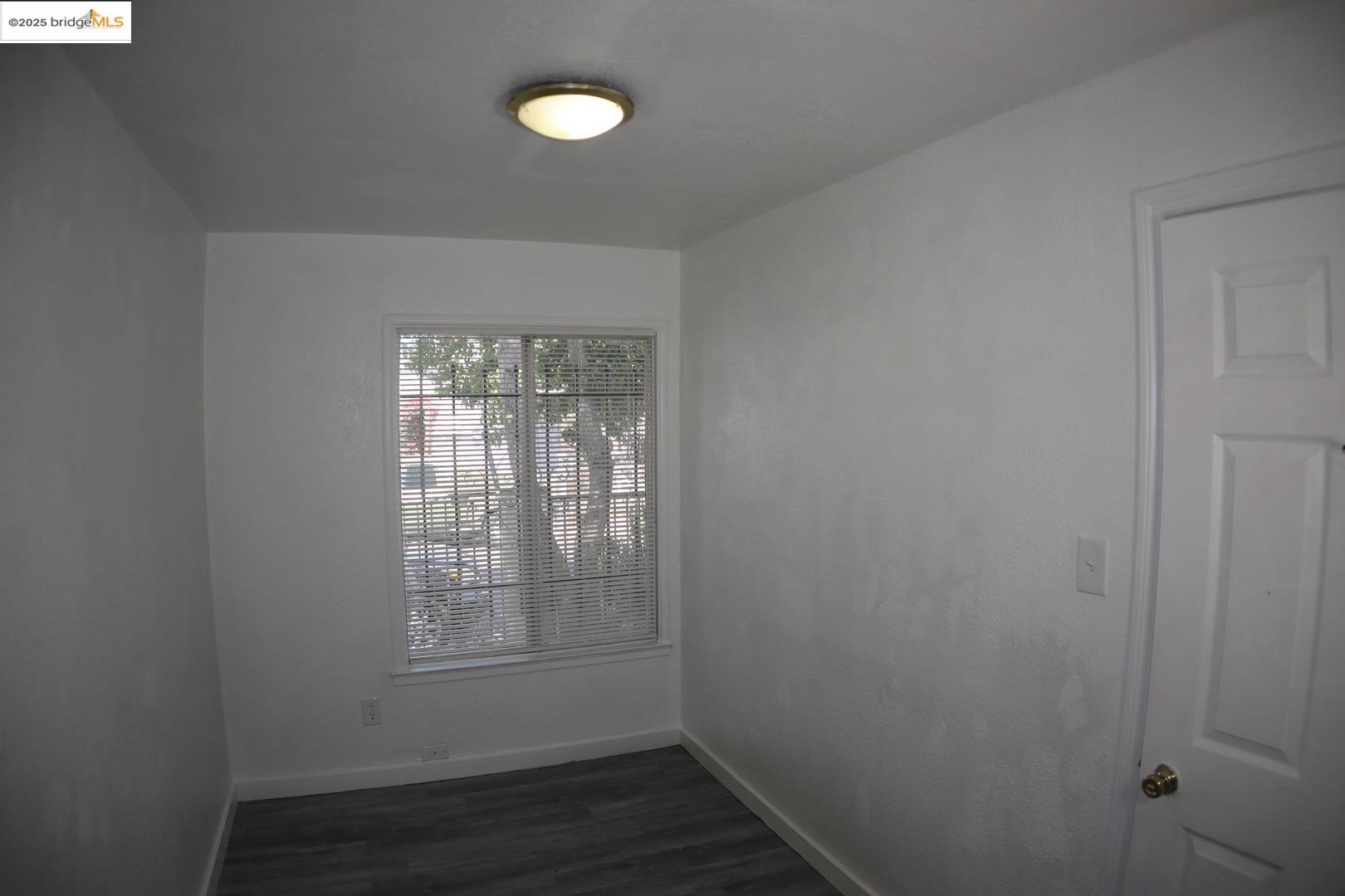 6921 Flora Street Oakland, CA 94621 - Photo 9 of 22 a view of an empty room with wooden floor and a window
