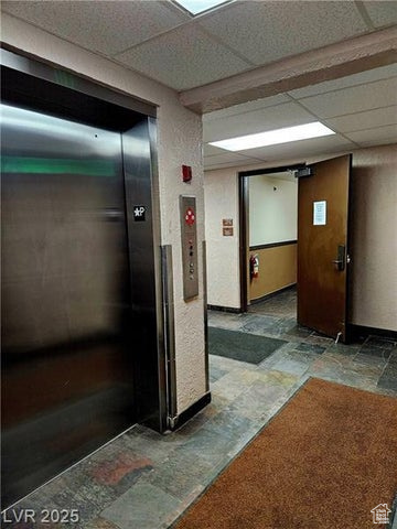 223 Hunter Ridge Drive, Unit E121 Brian Head, UT 84719 - Photo 29 of 35 Hall with stone tile flooring, elevator, and a drop ceiling