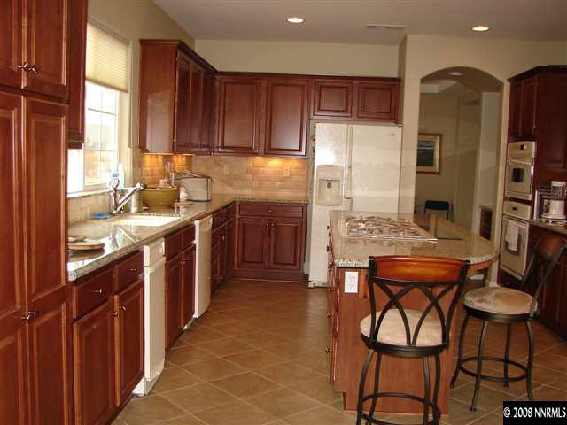 8105 Willow Ranch Trail Reno, NV 89523 - Photo 4 of 9 a kitchen with stainless steel appliances granite countertop a table chairs sink refrigerator and cabinets
