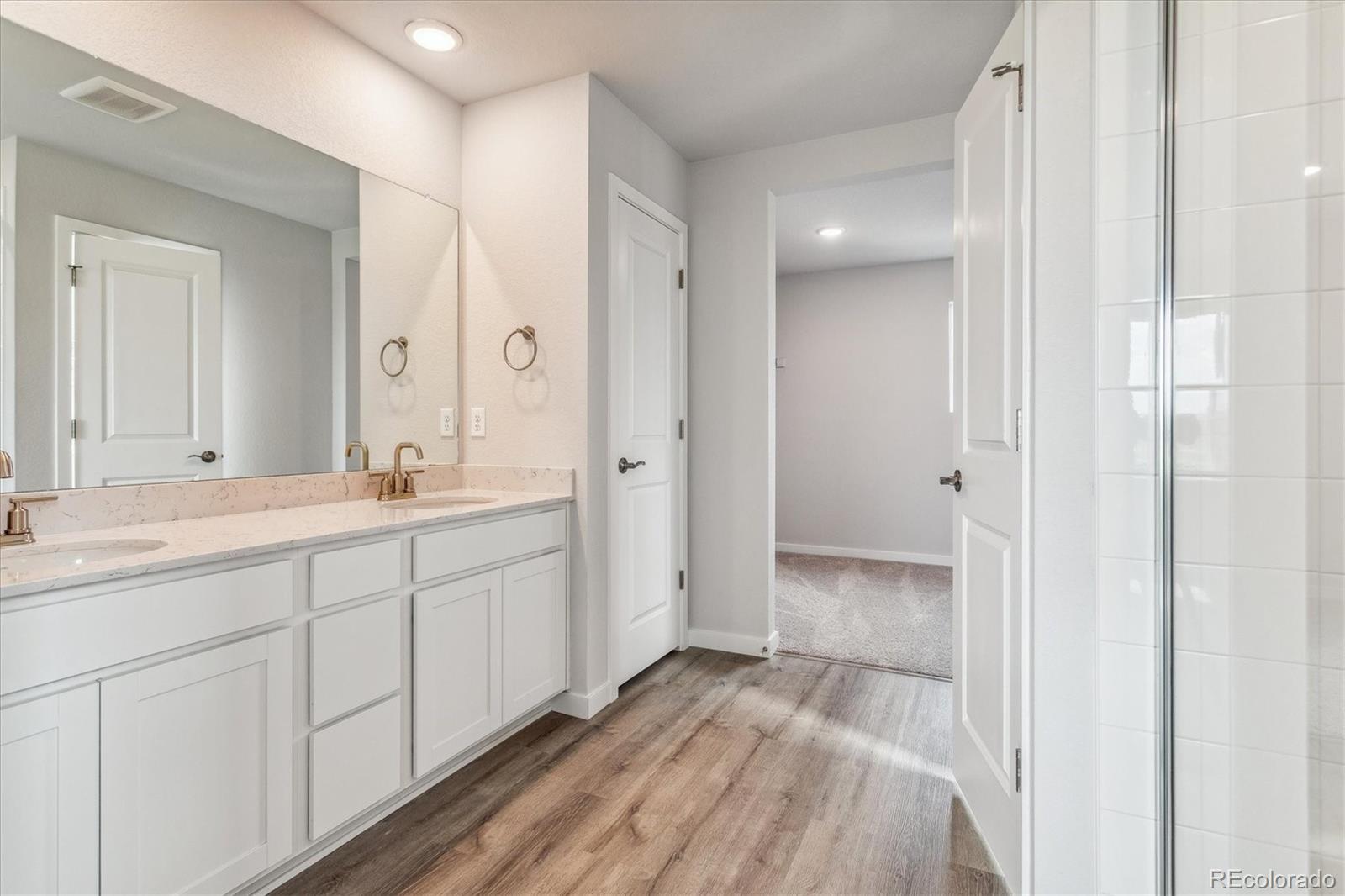 4255 Gozzer Ranch Drive Elizabeth, CO 80107 - Photo 17 of 21 a spacious bathroom with a shower sink and mirror
