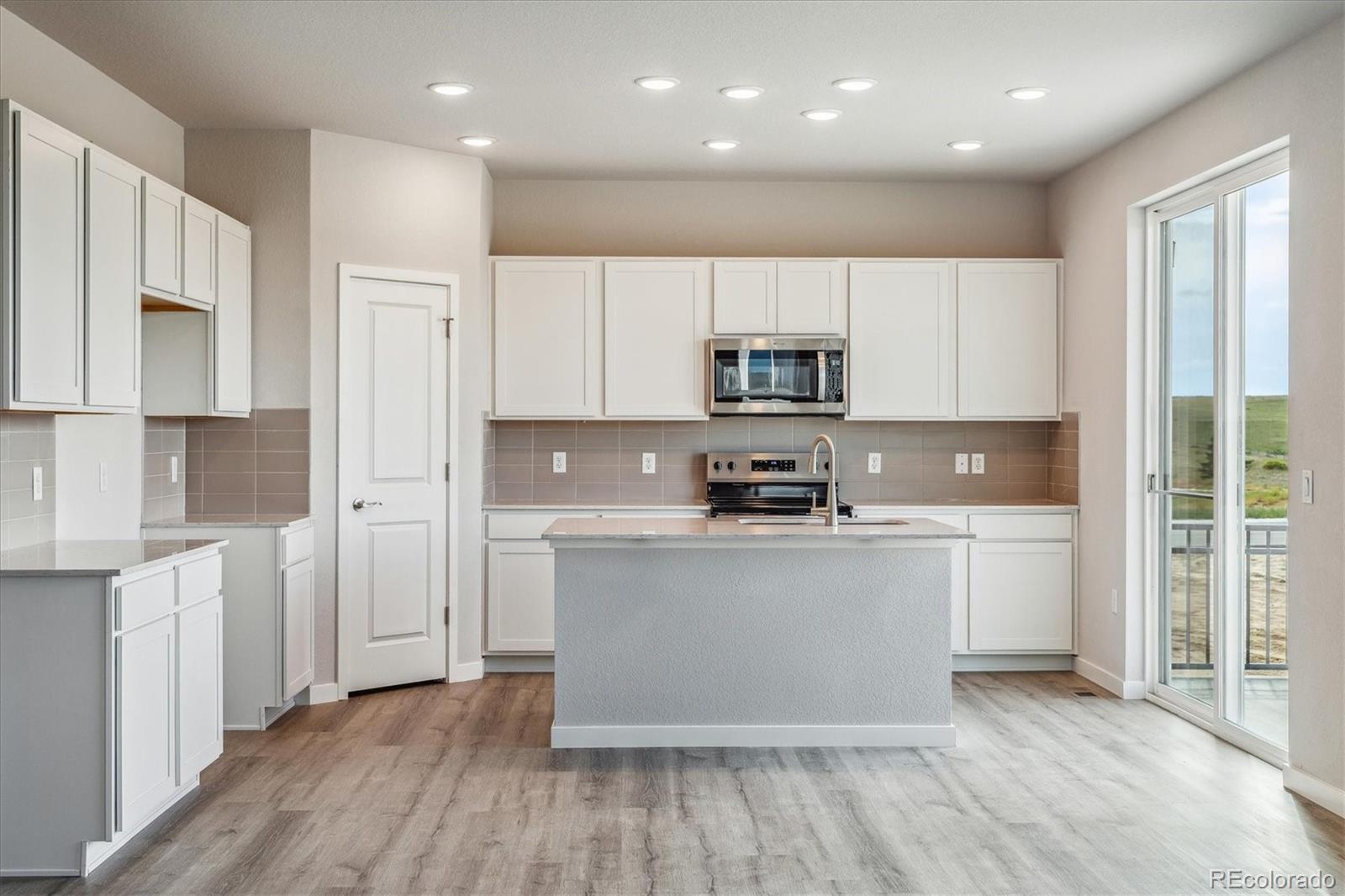 4255 Gozzer Ranch Drive Elizabeth, CO 80107 - Photo 2 of 21 a kitchen with stainless steel appliances a sink a stove a refrigerator and cabinets