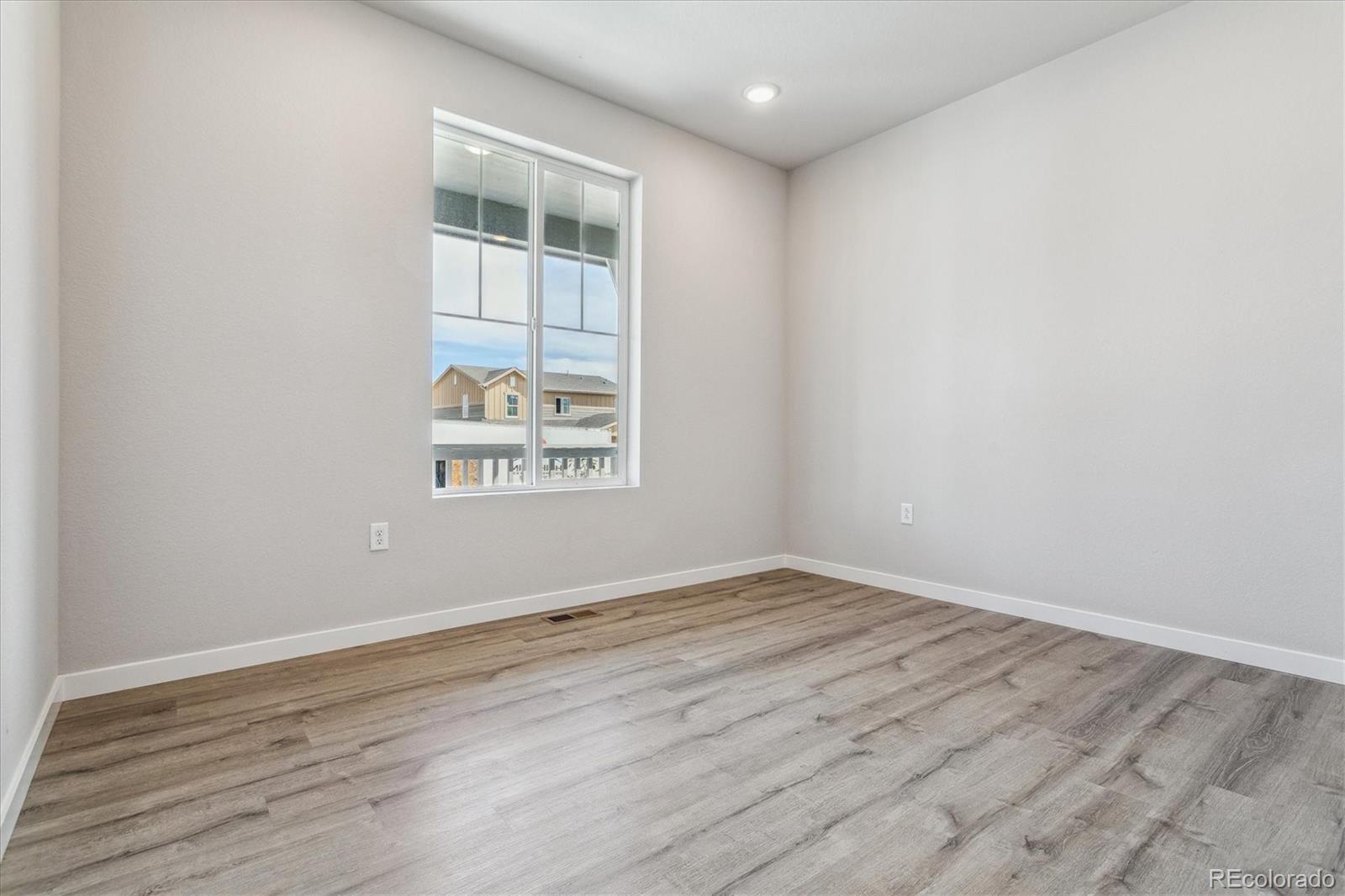 4255 Gozzer Ranch Drive Elizabeth, CO 80107 - Photo 6 of 21 an empty room with wooden floor and windows