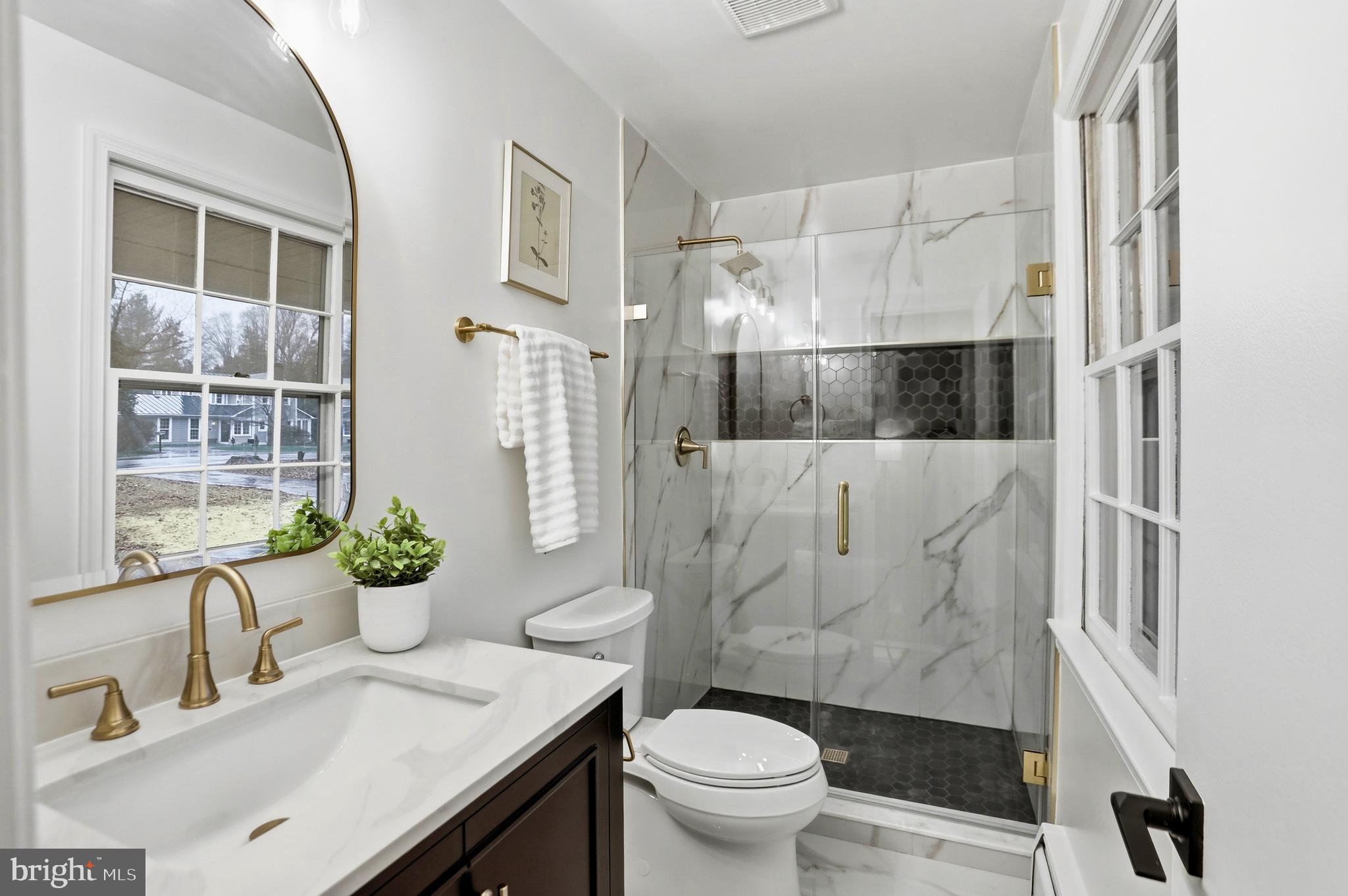 11328 Vale Road Oakton, VA 22124 - Photo 16 of 34 a bathroom with a granite countertop sink toilet and shower