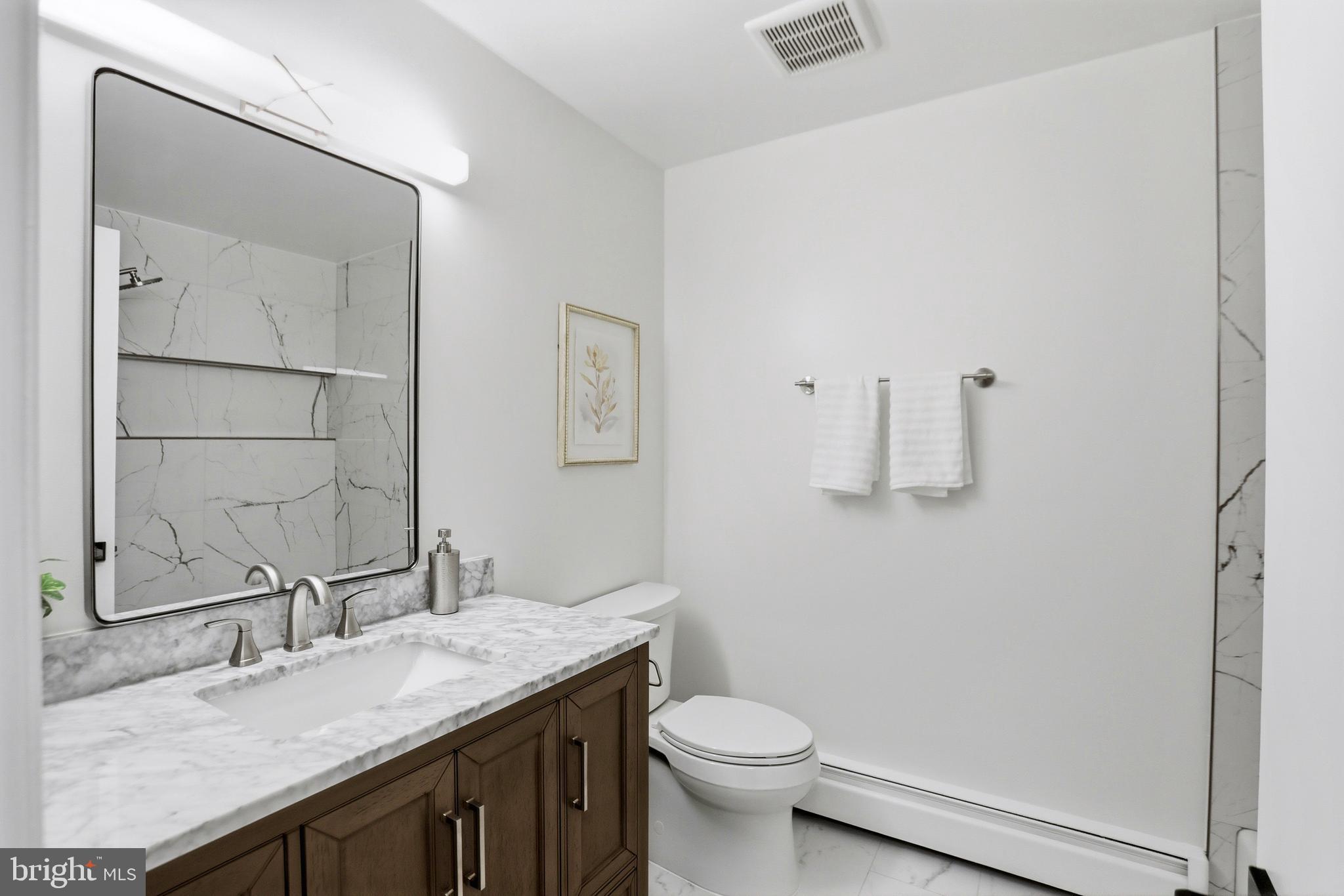 11328 Vale Road Oakton, VA 22124 - Photo 18 of 34 a bathroom with a granite countertop sink a toilet and a mirror