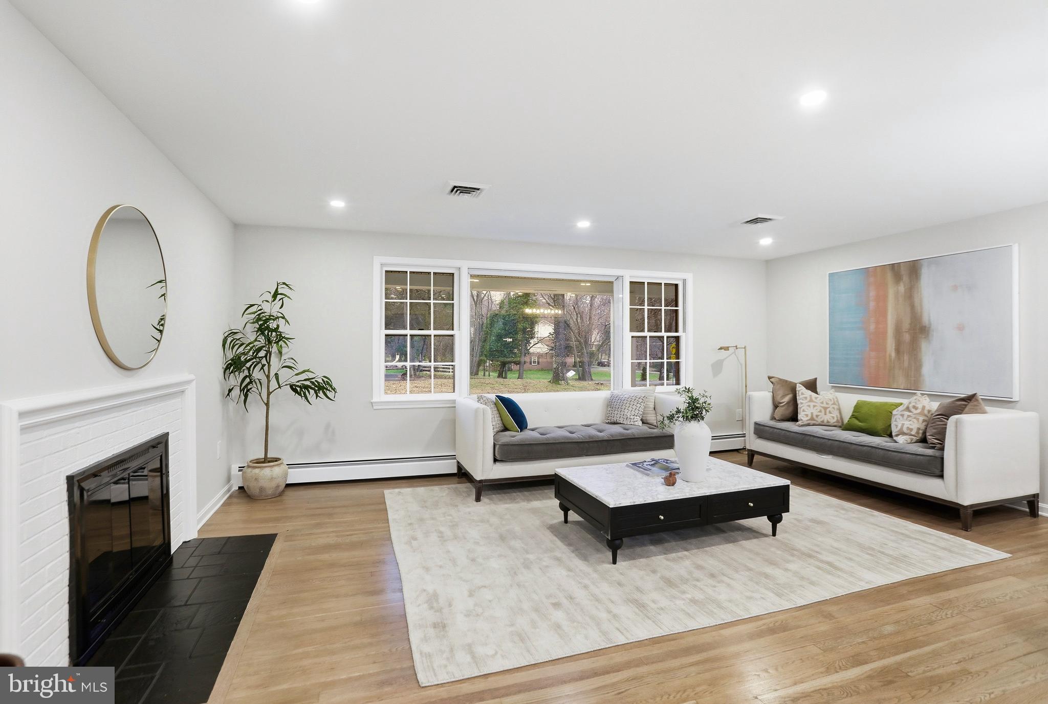 11328 Vale Road Oakton, VA 22124 - Photo 4 of 34 a living room with furniture a fireplace a lamp and a large window