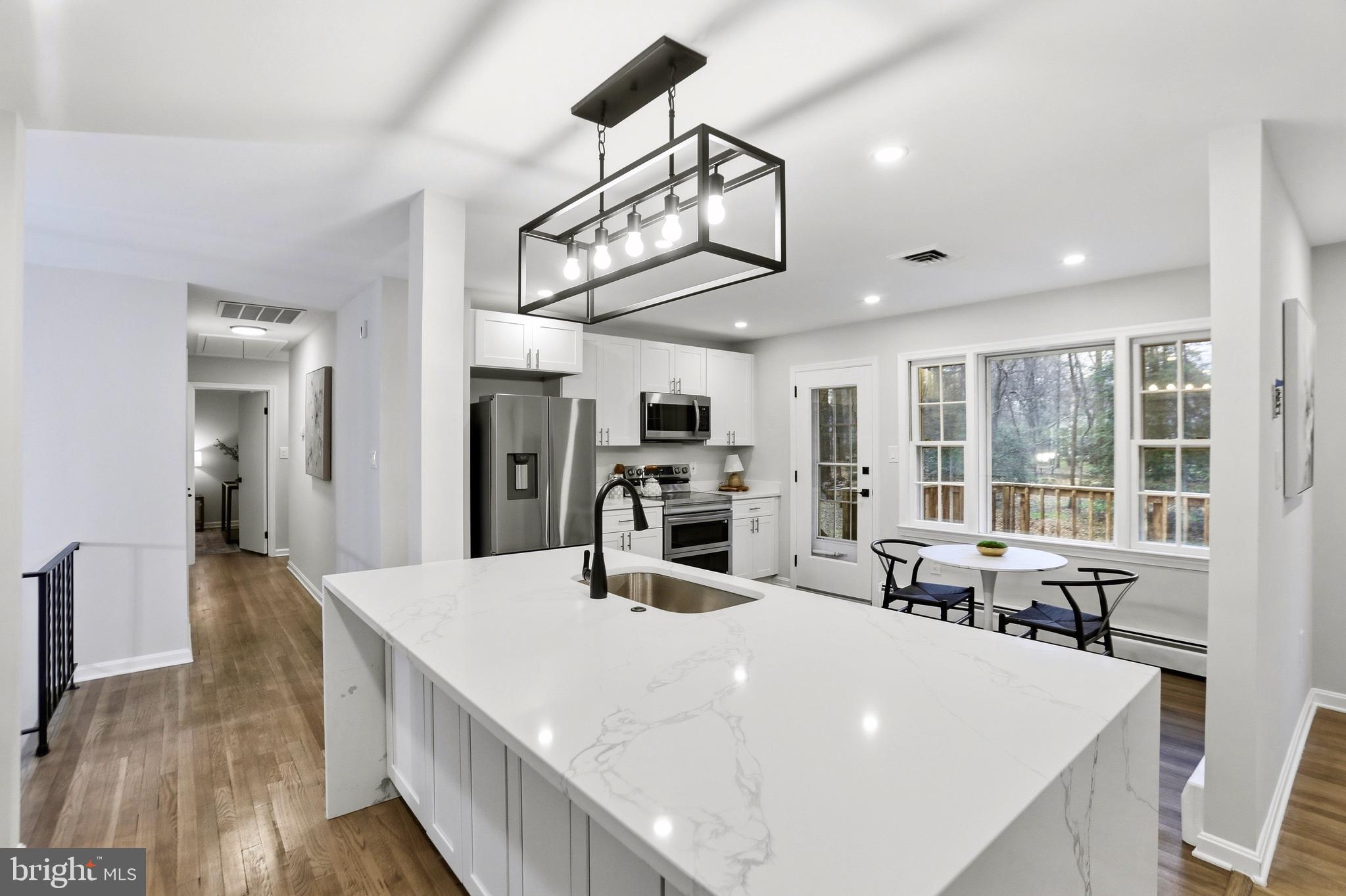11328 Vale Road Oakton, VA 22124 - Photo 8 of 34 a large kitchen with kitchen island a large counter space a sink appliances and living room view