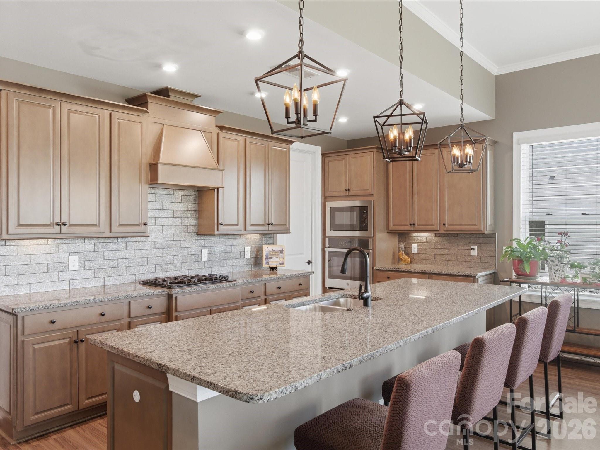 7004 Treetop Court York, SC 29745 - Photo 23 of 47 a kitchen with a center island a sink cabinets and stainless steel appliances