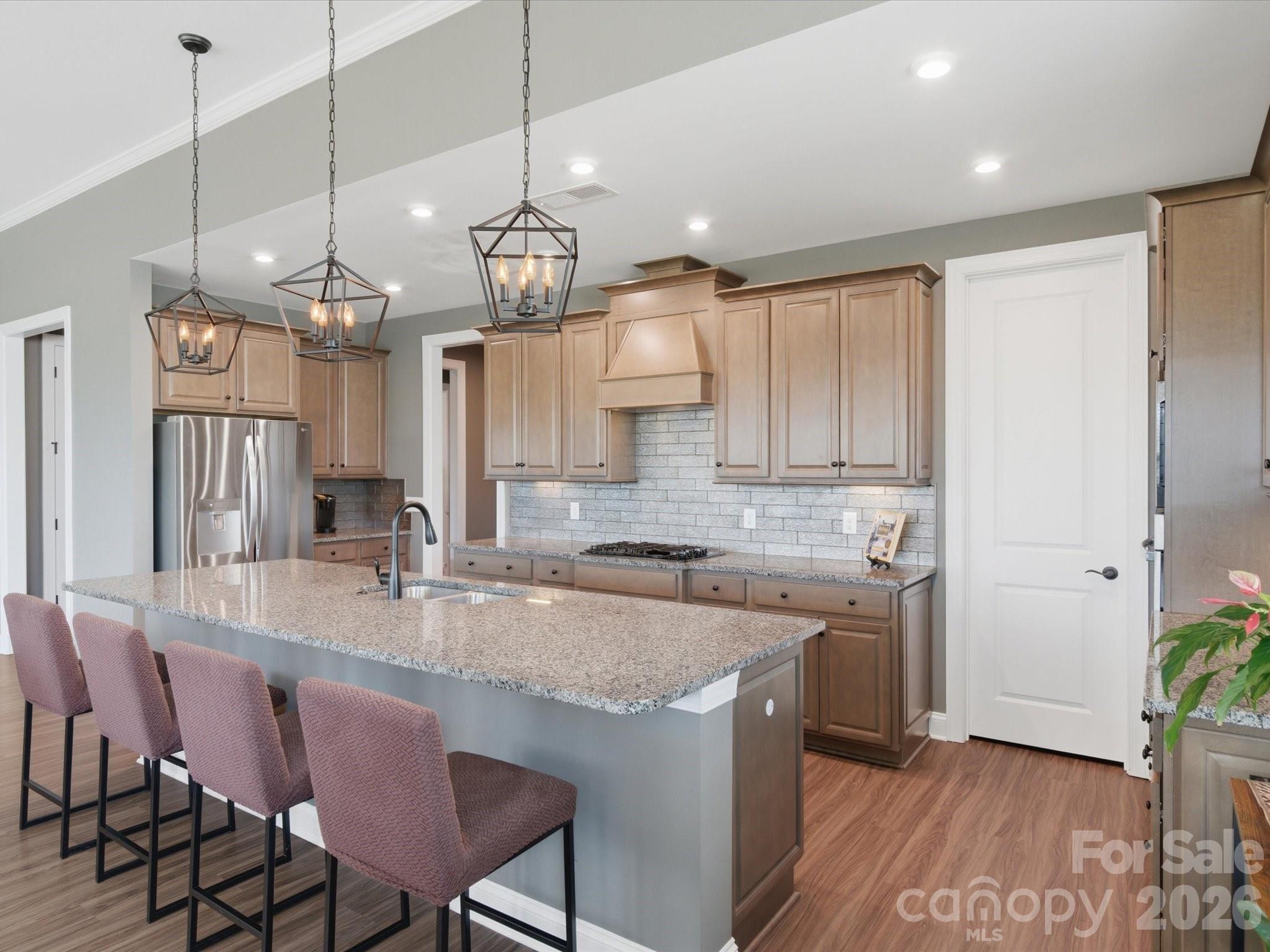 7004 Treetop Court York, SC 29745 - Photo 25 of 47 a kitchen with stainless steel appliances granite countertop a kitchen island a stove a table and chairs in it