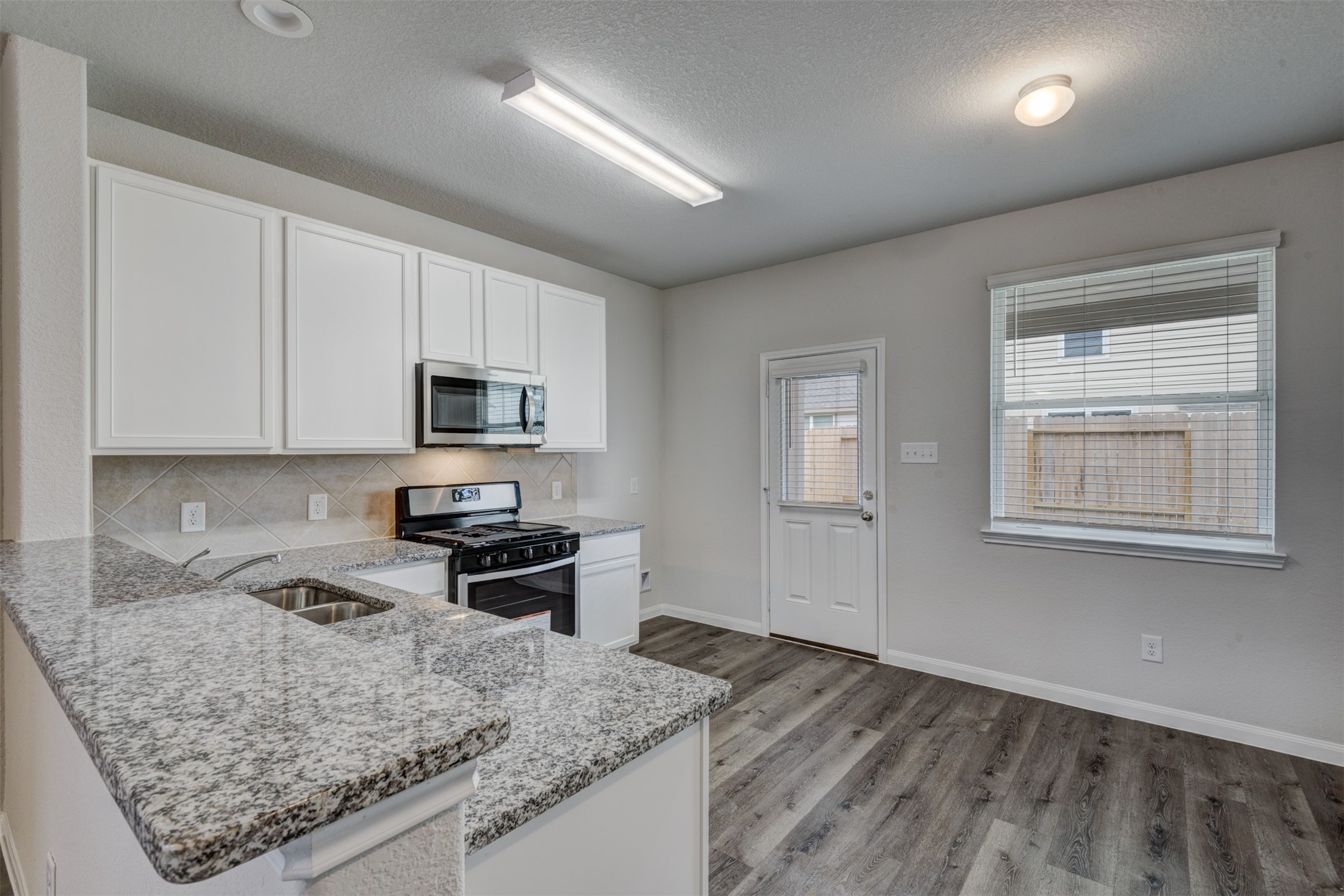 5011 Blue Jacaranda Way Spring Spring, TX 77373 - Photo 12 of 32 a kitchen with stainless steel appliances granite countertop a sink stove and microwave