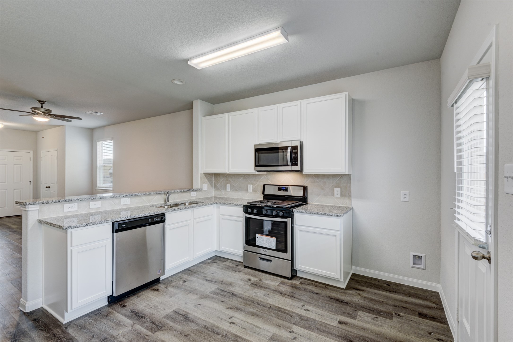 5011 Blue Jacaranda Way Spring Spring, TX 77373 - Photo 13 of 32 a kitchen with stainless steel appliances granite countertop a stove and a sink