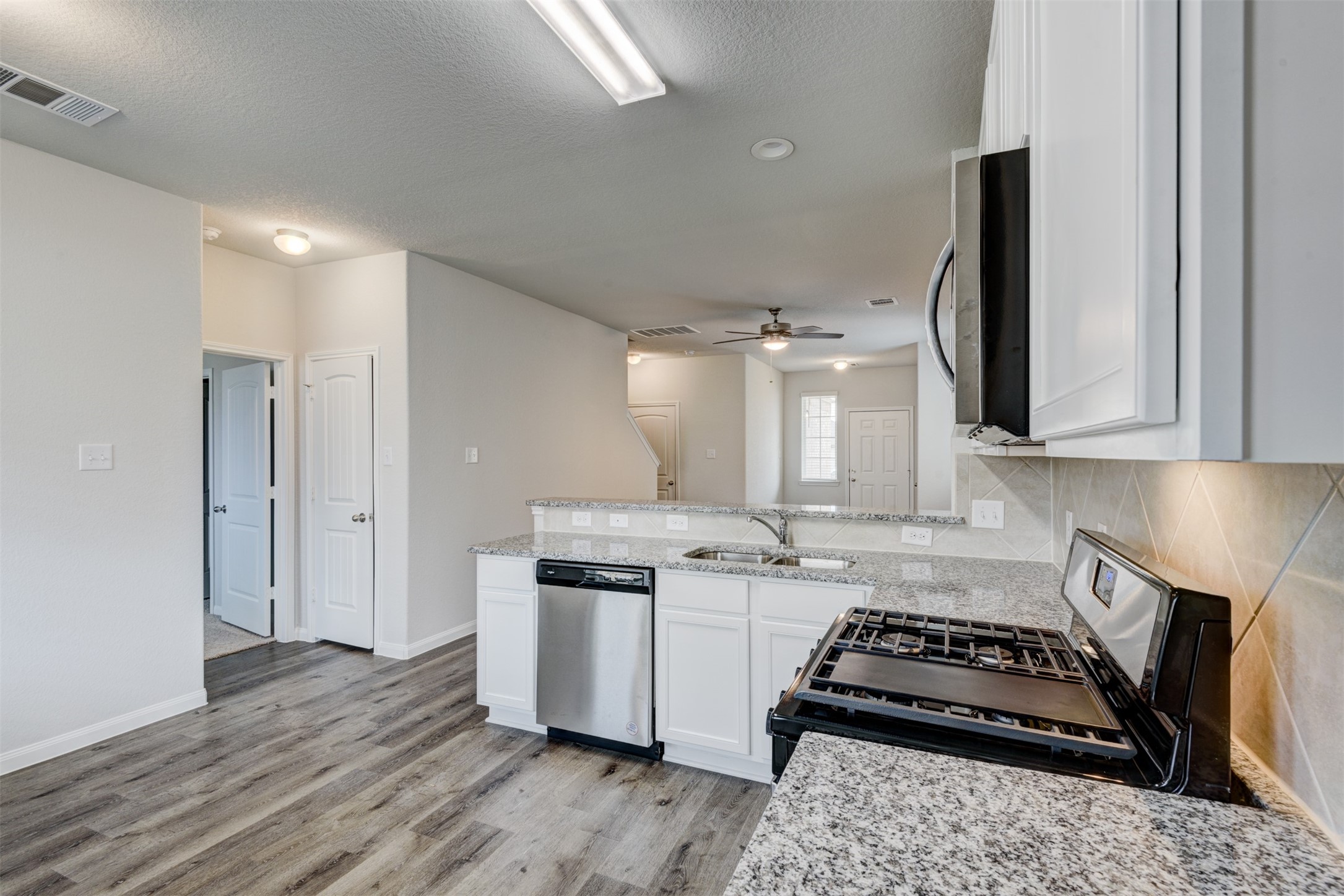 5011 Blue Jacaranda Way Spring Spring, TX 77373 - Photo 14 of 32 a kitchen with stainless steel appliances granite countertop a stove a sink and a refrigerator