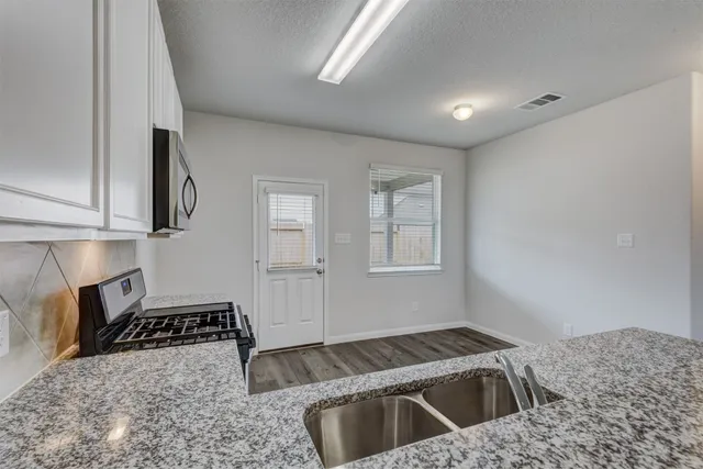 a kitchen that has a sink and a stove in it