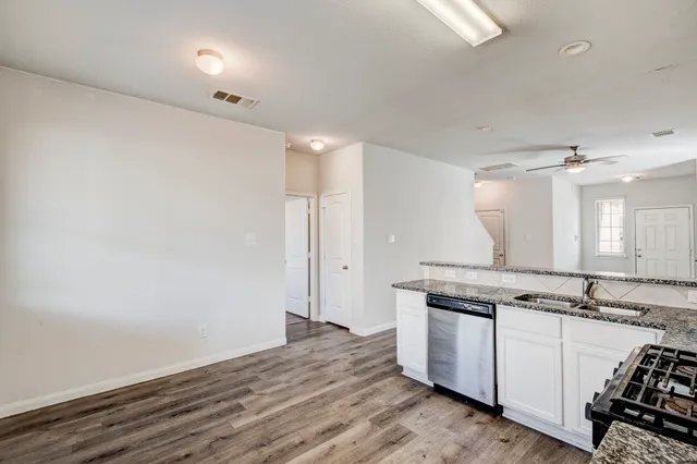 a view of a kitchen counter space a stove and wooden floor