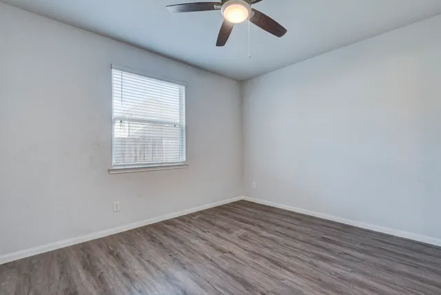 wooden floor in an empty room with a window