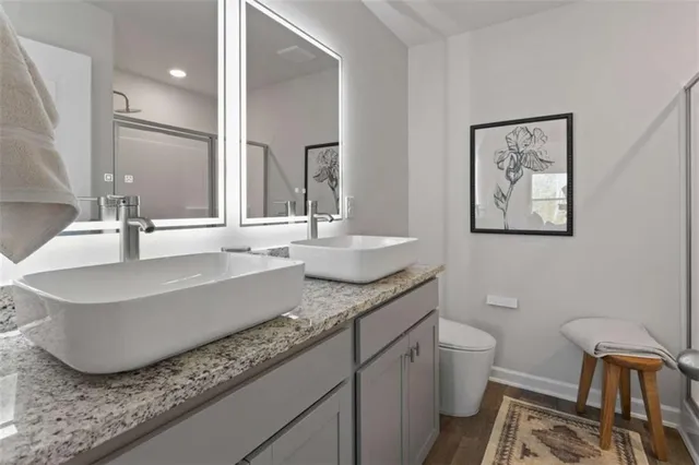 a bathroom with a granite countertop sink and a large mirror