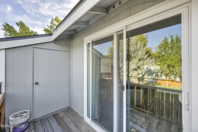 a view of a porch with wooden floor and a gate