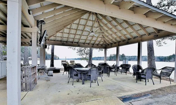 a view of a patio with table and chairs potted plants and large tree