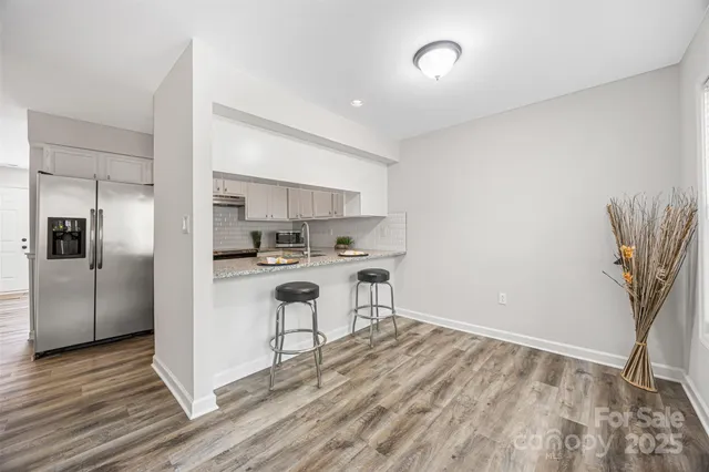 a kitchen with stainless steel appliances granite countertop a refrigerator and a stove top oven