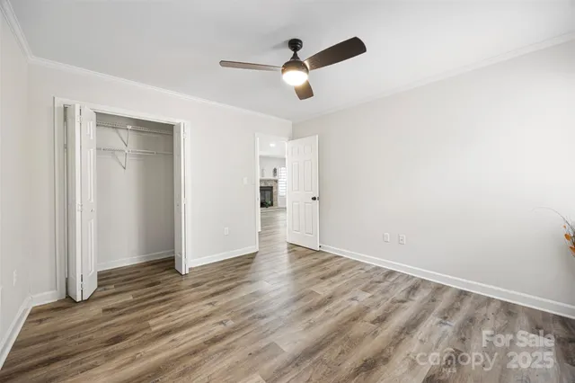an empty room with wooden floor and ceiling fan