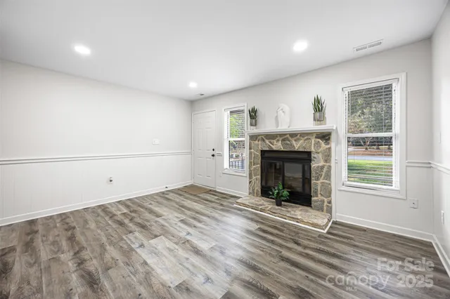an empty room with windows and fireplace