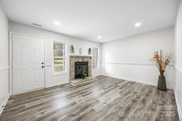 a view of empty room with a fireplace and wooden floor