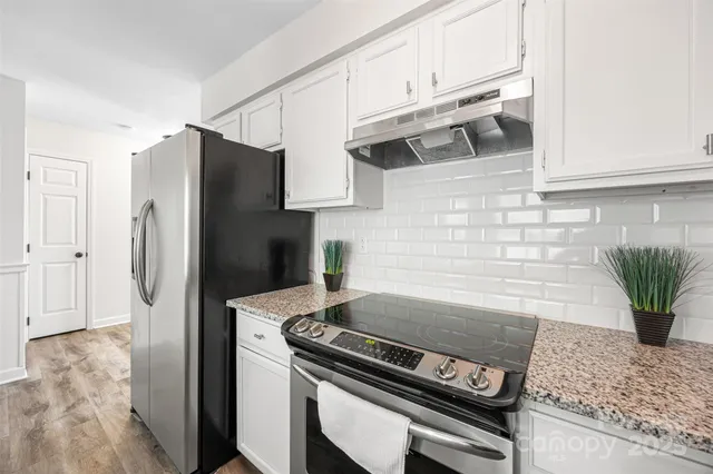 a kitchen with stainless steel appliances granite countertop a refrigerator and a stove