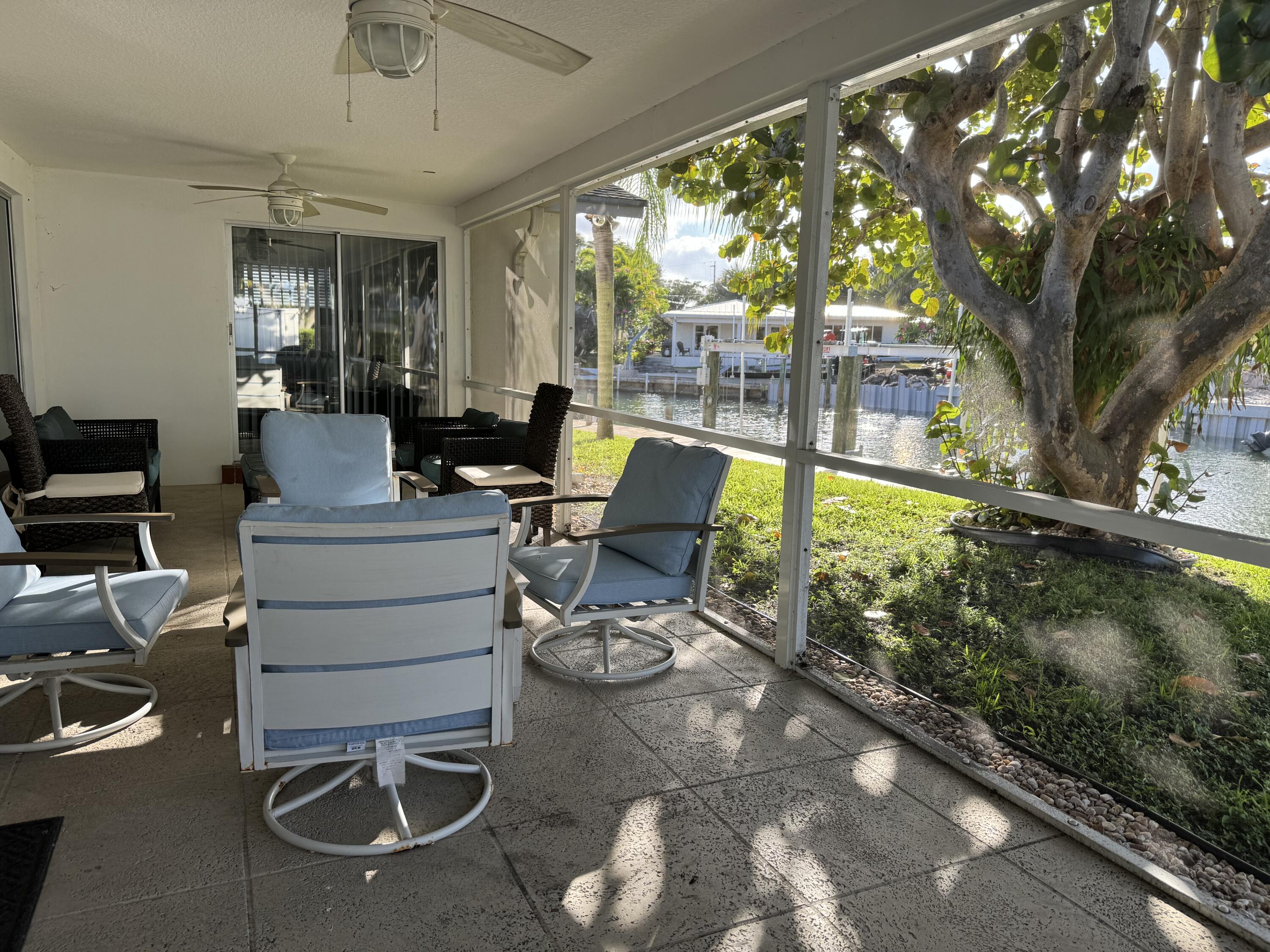 954 Marlin Circle Jupiter, FL 33458 - Photo 18 of 22 a living room with patio furniture and a floor to ceiling window