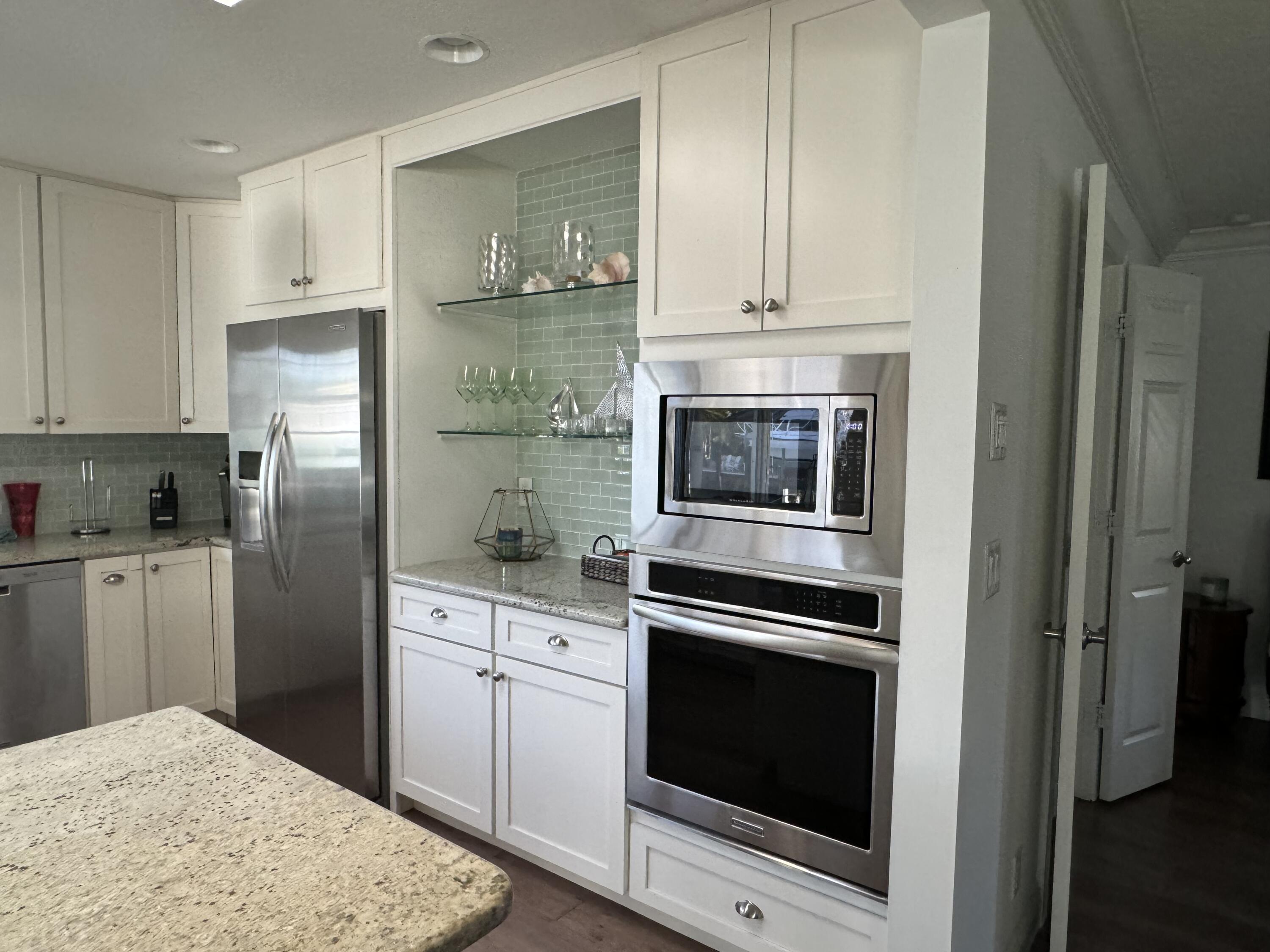 954 Marlin Circle Jupiter, FL 33458 - Photo 2 of 22 a kitchen with granite countertop white cabinets and stainless steel appliances