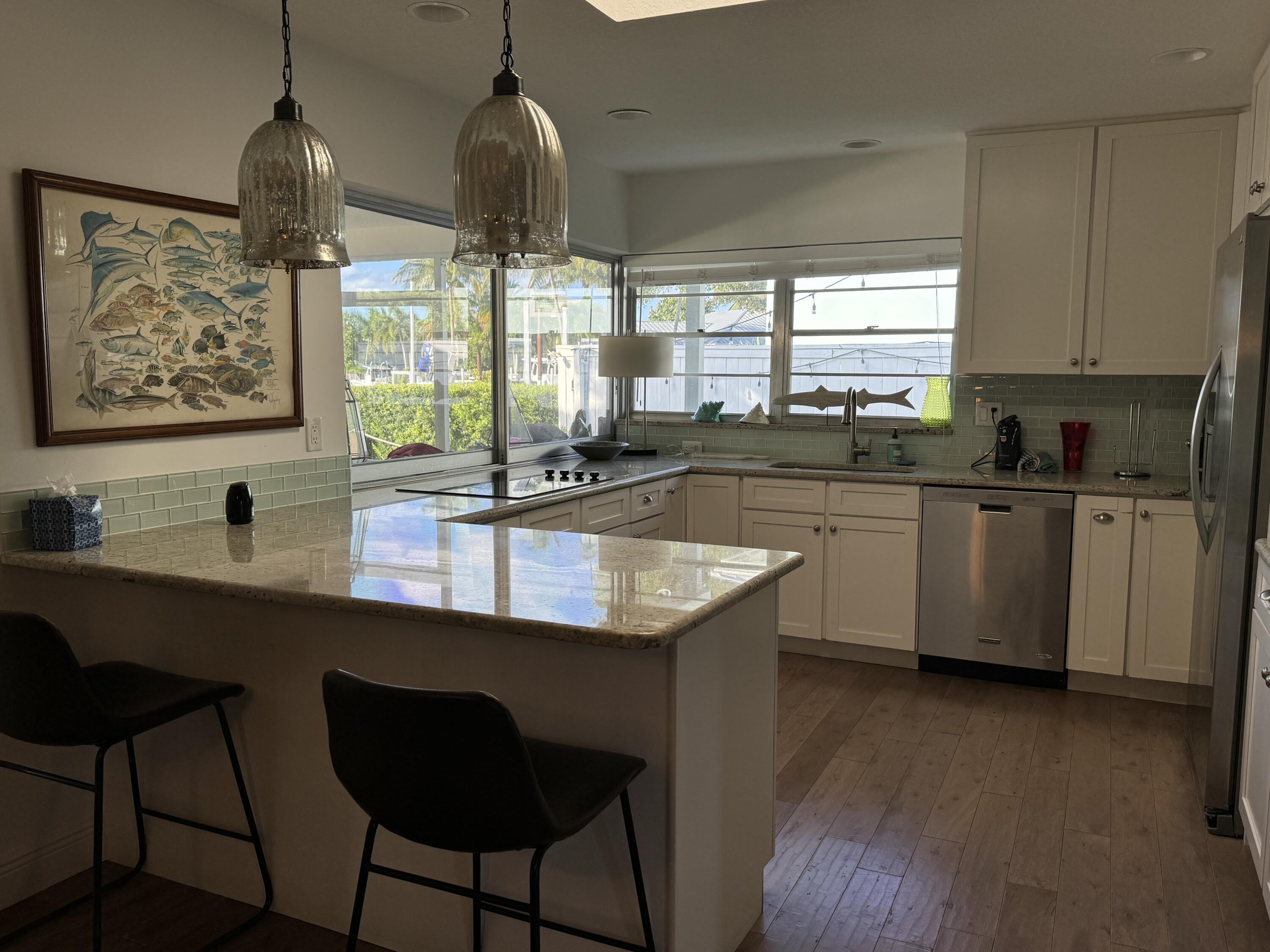 954 Marlin Circle Jupiter, FL 33458 - Photo 3 of 22 a kitchen with stainless steel appliances granite countertop a sink a stove and wooden floor