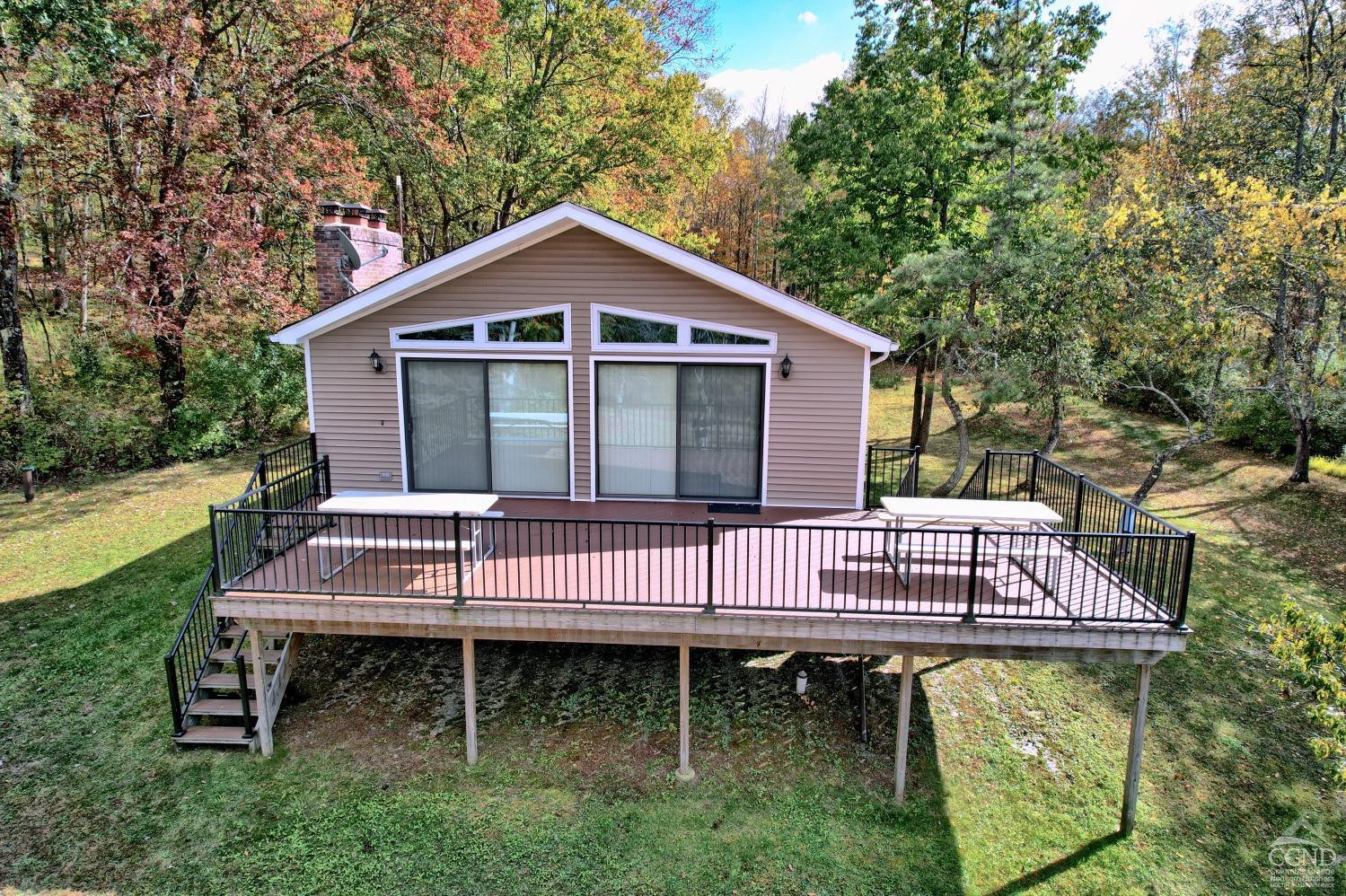 496 New Forge Road Ancram, NY 12502 - Photo 12 of 87 a view of a deck with a yard chairs and a large tree