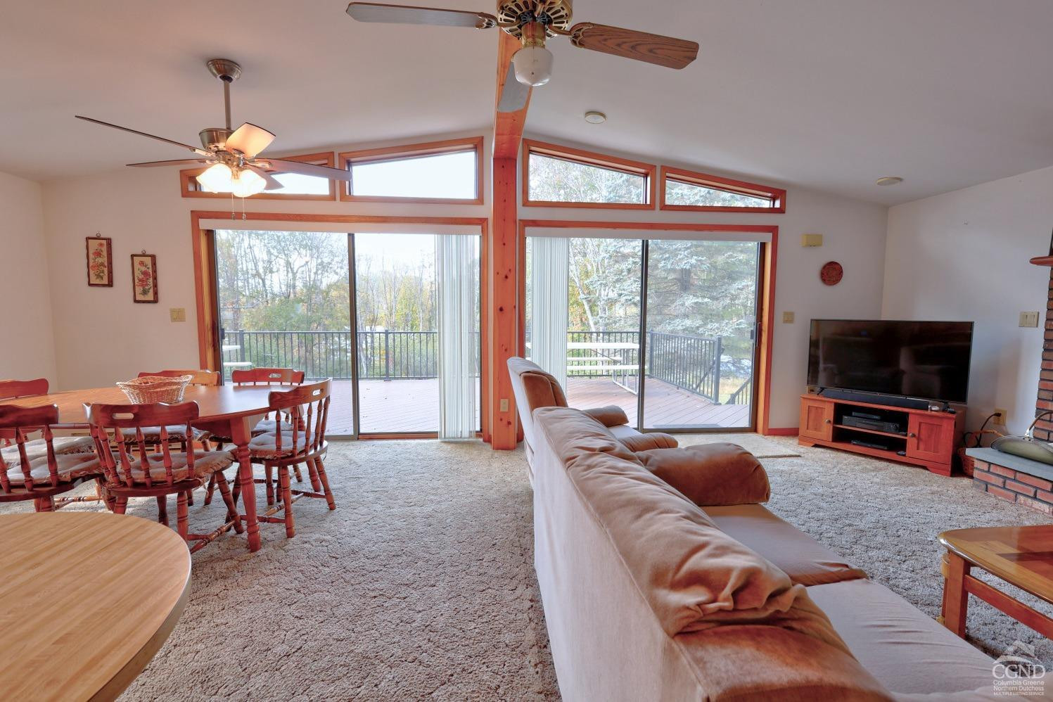 496 New Forge Road Ancram, NY 12502 - Photo 32 of 87 a living room with furniture a flat screen tv and a large window