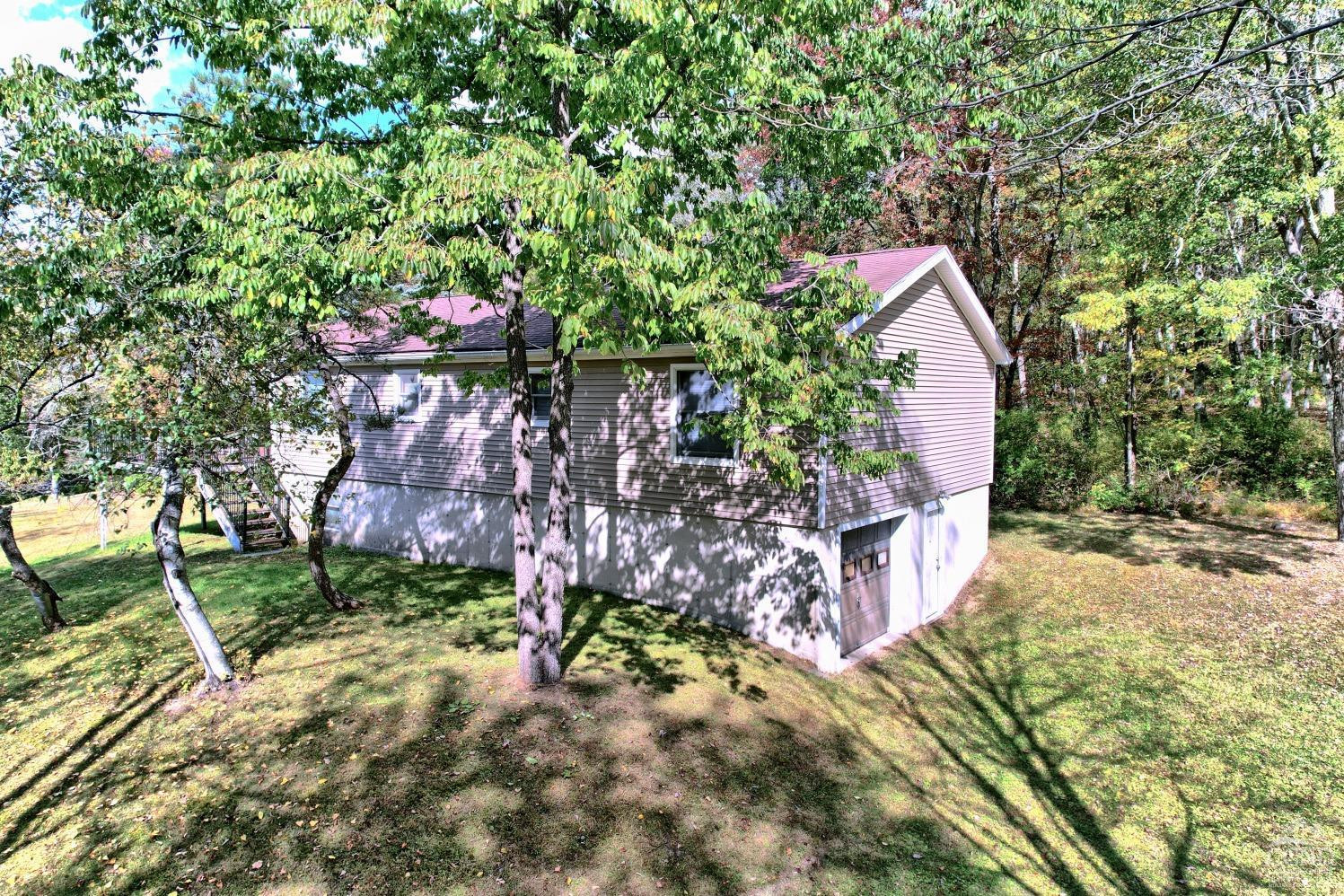 496 New Forge Road Ancram, NY 12502 - Photo 7 of 87 a view of a wooden house with a yard and plants
