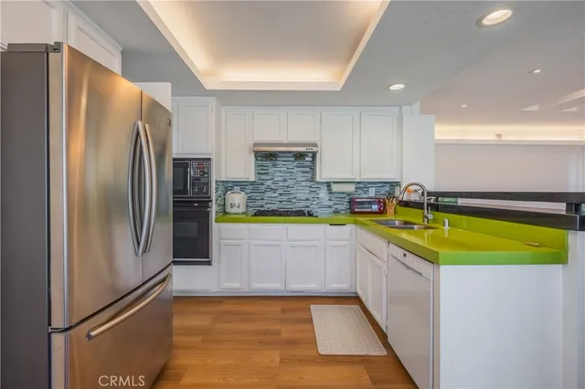a kitchen with stainless steel appliances granite countertop a refrigerator a sink and a stove