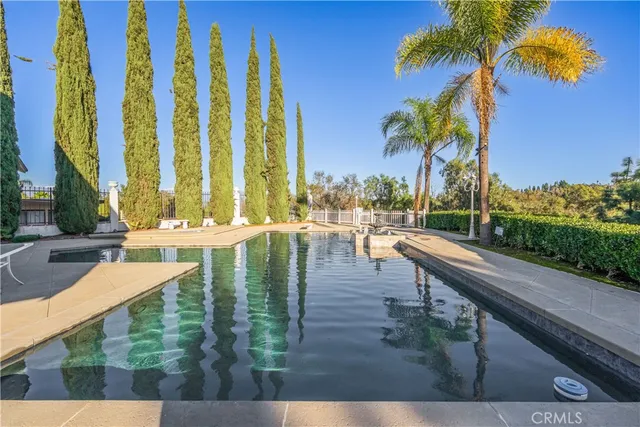 a view of swimming pool with lawn chairs and couches