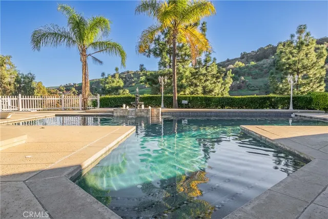 a view of a swimming pool with a lawn chairs under an umbrella