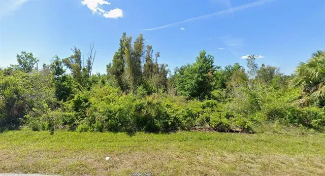 a view of a green yard with a house in the background