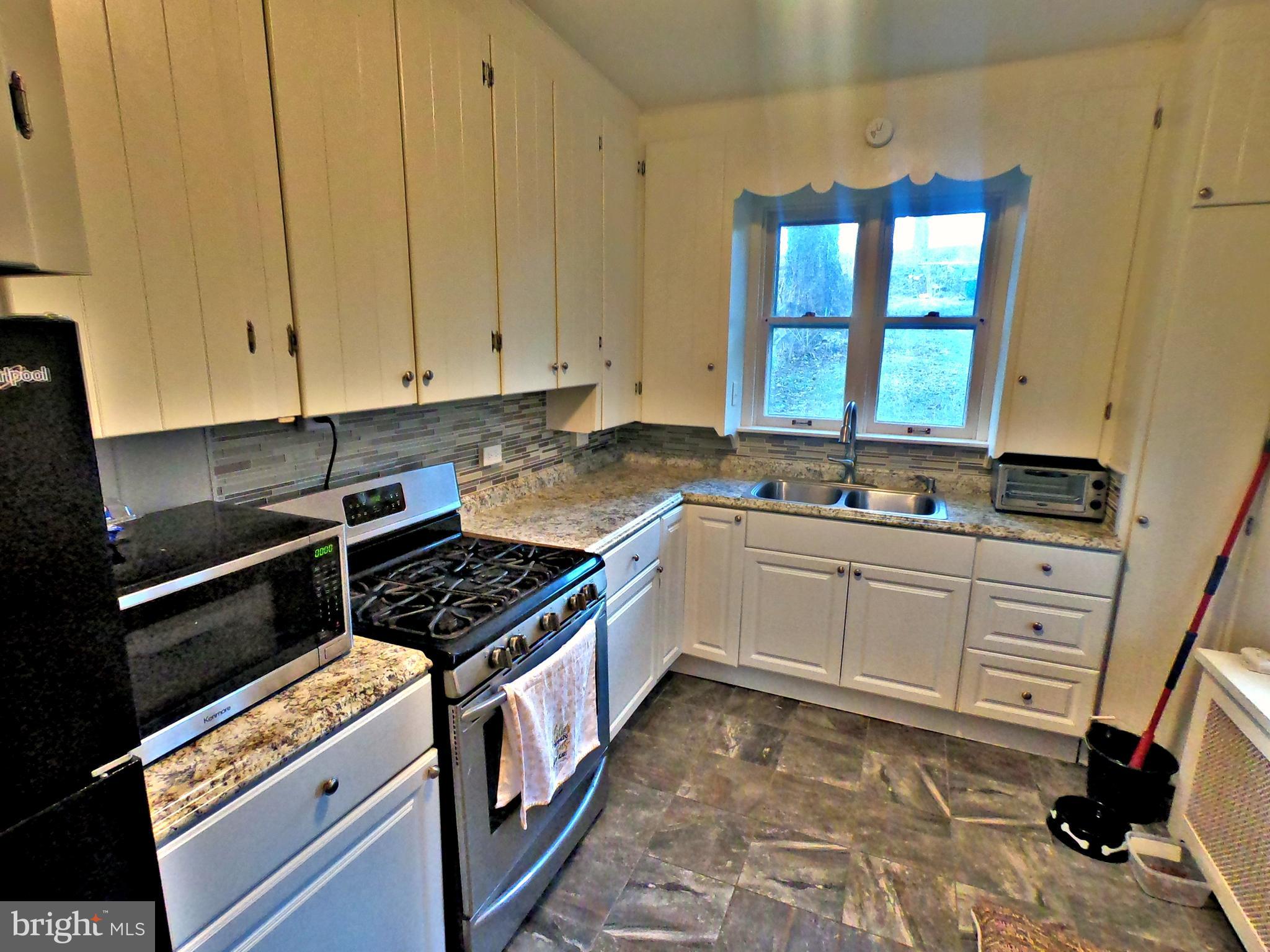 4133 Penn Avenue Sinking Spring, PA 19608 - Photo 11 of 53 a kitchen with granite countertop a stove and white cabinets