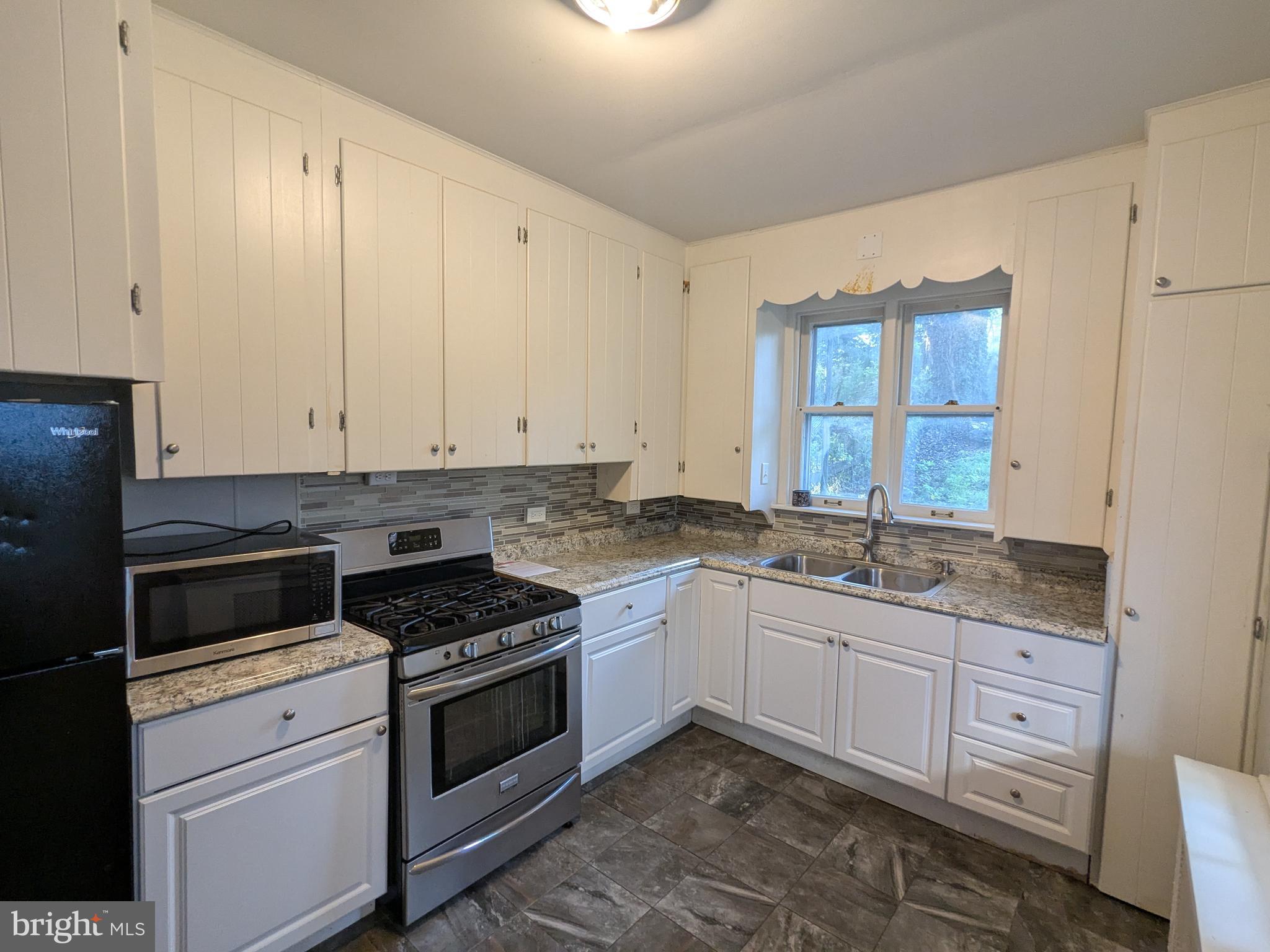 4133 Penn Avenue Sinking Spring, PA 19608 - Photo 26 of 53 a kitchen with granite countertop a stove sink and cabinets
