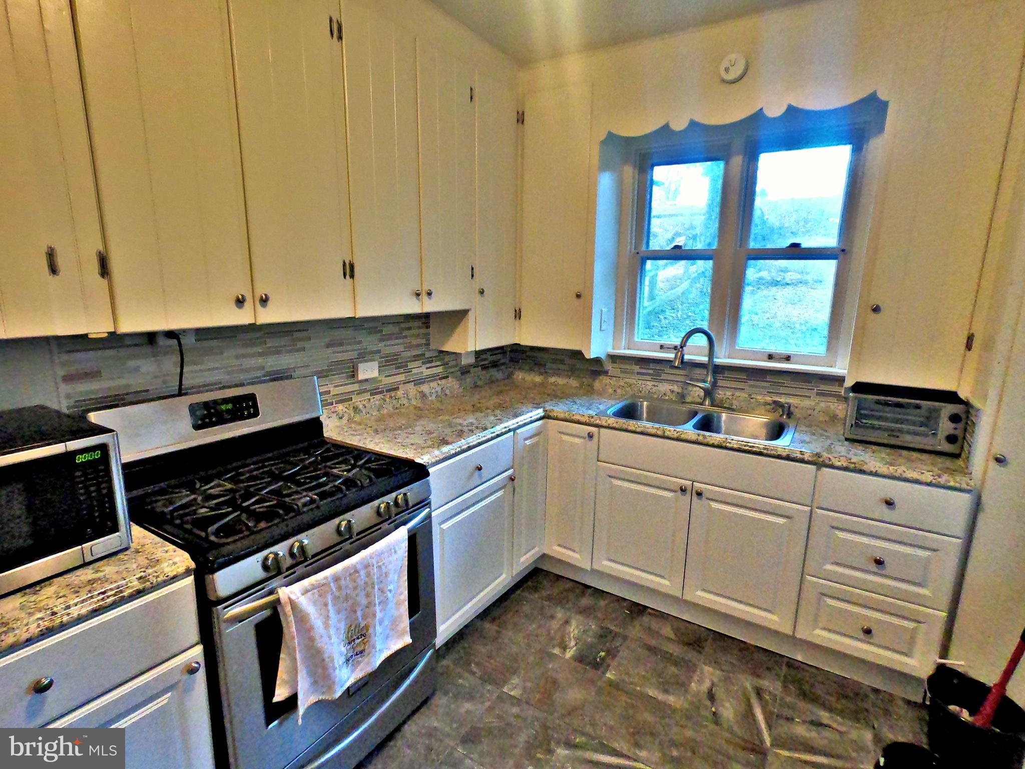 4133 Penn Avenue Sinking Spring, PA 19608 - Photo 9 of 53 a kitchen with granite countertop a stove sink and cabinets