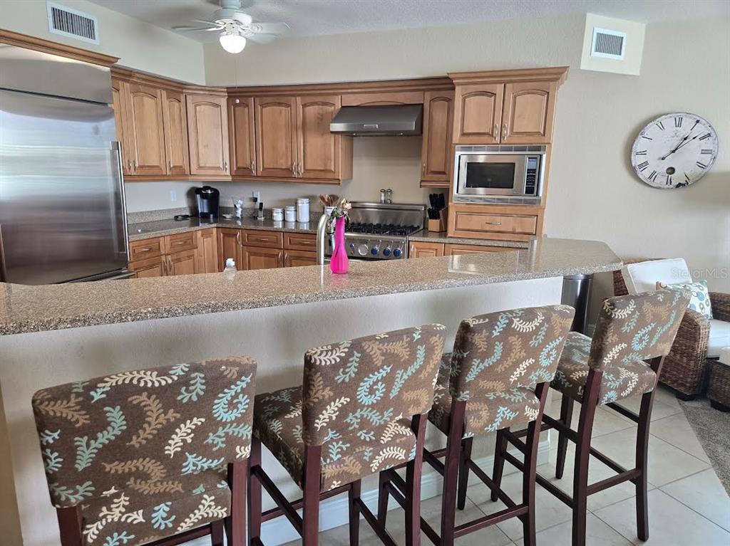 650 Golden Gate Point, Unit 301 Sarasota, FL 34236 - Photo 16 of 31 a kitchen with stainless steel appliances granite countertop a table chairs in it and wooden floors