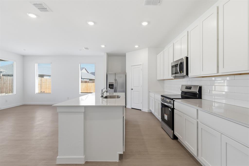 4912 Ascot Way Princeton, TX 75407 - Photo 16 of 35 a large kitchen with cabinets