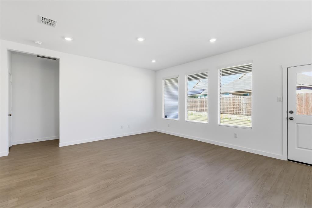 4912 Ascot Way Princeton, TX 75407 - Photo 20 of 35 a view of an empty room with wooden floor and a window