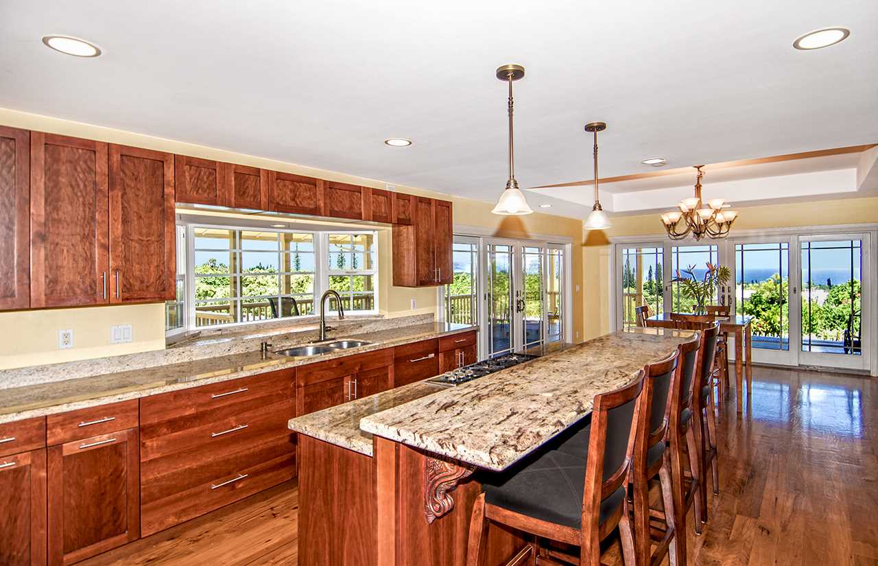 230-240 Mauu Place Haiku, HI 96708 - Photo 5 of 16 a kitchen with stainless steel appliances granite countertop a stove a kitchen island a table and chairs in it