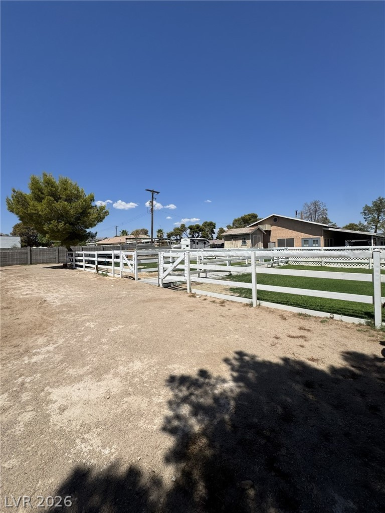 167 East Robindale Road Las Vegas, NV 89123 - Photo 10 of 15 Sturdy vinyl fencing encloses manicured green pastures under clear blue desert skies.