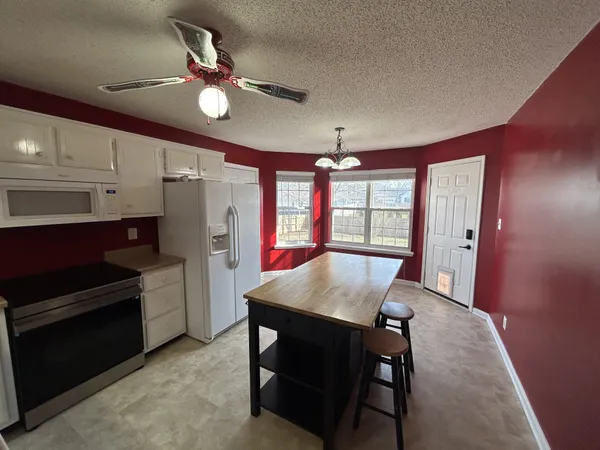 a kitchen with a table chairs refrigerator and cabinets