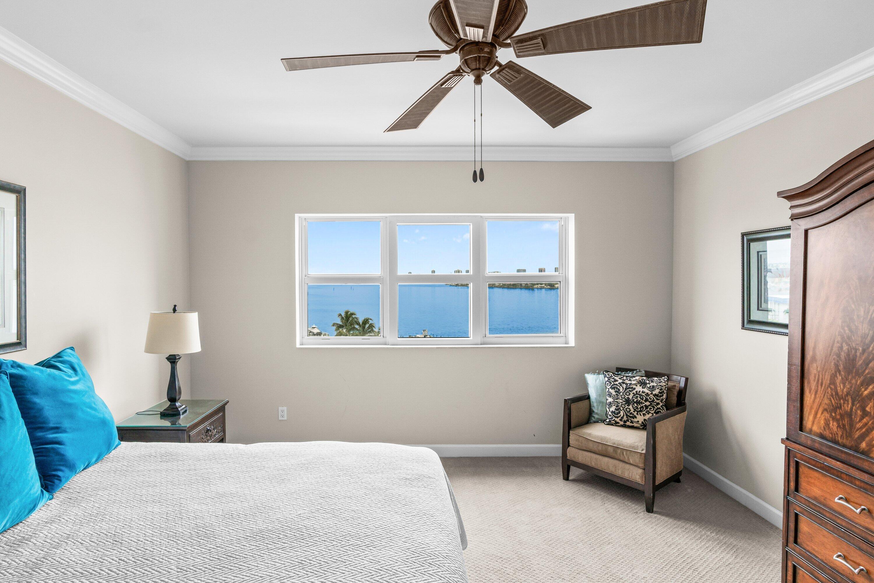 2650 Lake Shore Drive, Unit 703 Riviera Beach, FL 33404 - Photo 15 of 56 a bedroom with a bed and a chandelier