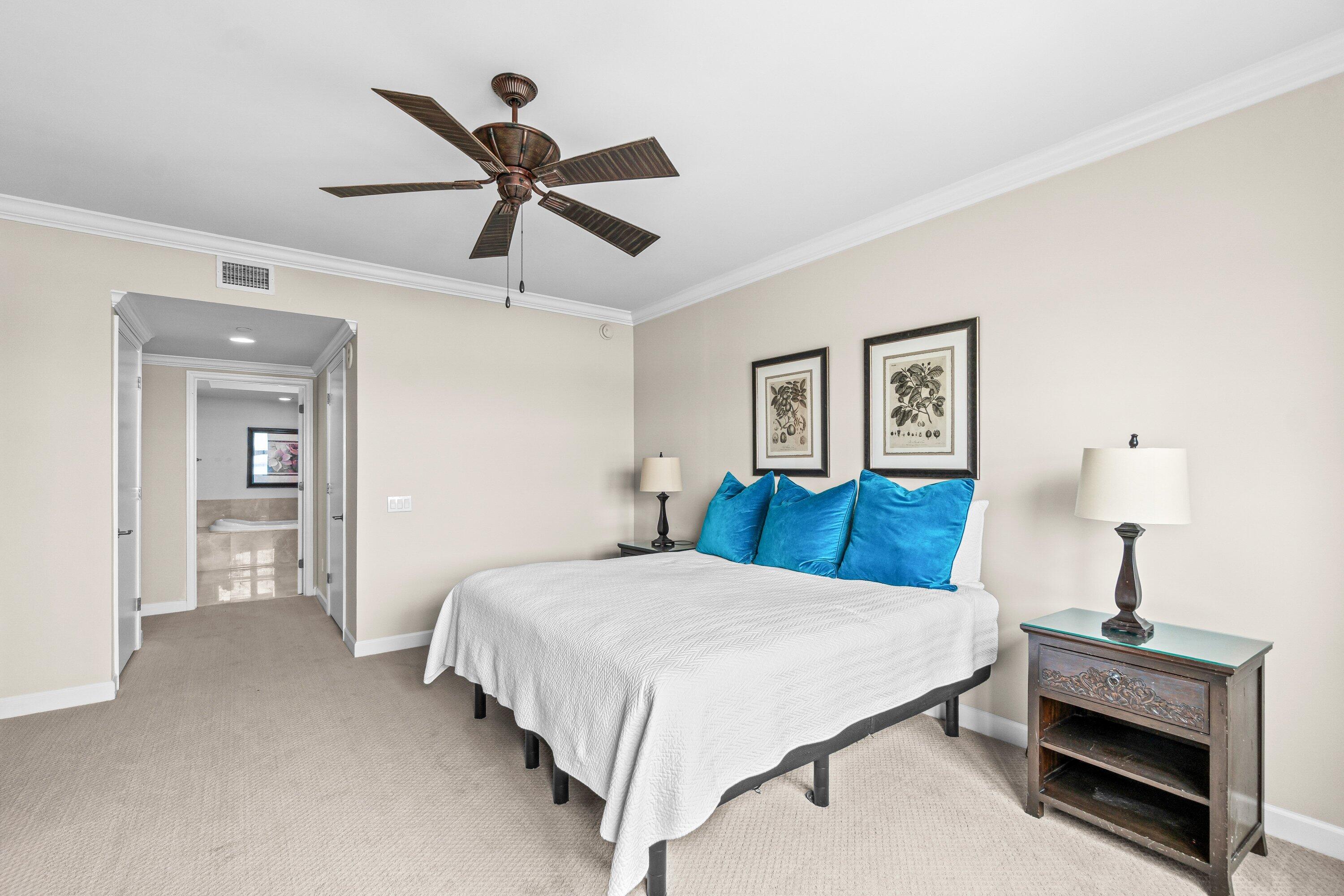 2650 Lake Shore Drive, Unit 703 Riviera Beach, FL 33404 - Photo 16 of 56 a bedroom with a bed and a chandelier